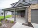 View of the covered front porch with stone columns and a dark-colored front door at 7517 Big Bend Blvd, Camby, IN 46113