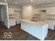 Spacious kitchen features a large center island with sink and countertop seating, and white cabinetry at 7517 Big Bend Blvd, Camby, IN 46113