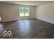 Open living room features durable wood-look flooring, neutral walls and a large window for natural light at 7517 Big Bend Blvd, Camby, IN 46113