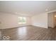 Living room with wood-look flooring, bright white walls and view to entry and dining at 7517 Big Bend Blvd, Camby, IN 46113