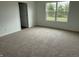 A bright carpeted bedroom featuring a large window with a view of trees at 7605 Big Bend Blvd, Camby, IN 46113
