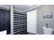 Clean bathroom with a modern shower curtain, storage cabinet, and neutral gray walls at 80 E College Ave, Martinsville, IN 46151