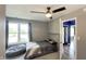 Cozy bedroom with a ceiling fan, natural light, and hallway view of the front door with blue accent wall at 80 E College Ave, Martinsville, IN 46151