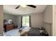 Bedroom with ceiling fan, view of the backyard, and a dresser featuring a television at 80 E College Ave, Martinsville, IN 46151