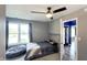 Neutral bedroom with a window, ceiling fan, and an open doorway to another room at 80 E College Ave, Martinsville, IN 46151