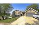 Single story brick home with attached garage, mature landscaping, and a driveway with parked cars at 80 E College Ave, Martinsville, IN 46151
