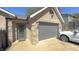 Single story brick home with an attached gray garage and mature landscaping at 80 E College Ave, Martinsville, IN 46151