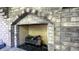 Close-up of a brick fireplace with a decorative log set and black gravel base at 80 E College Ave, Martinsville, IN 46151