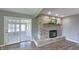 Bright living room featuring a brick fireplace, hardwood floors, and french doors to sunroom at 80 E College Ave, Martinsville, IN 46151