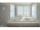 Luxurious bathroom with a soaking tub, surrounded by windows and patterned walls at 858 Cedar Wood, Carmel, IN 46032