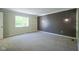 Bright bedroom featuring a large window, neutral carpet, and a wood paneled accent wall at 858 Cedar Wood, Carmel, IN 46032