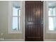 Close up of the dark wood front door with sidelight windows and neutral colored walls at 858 Cedar Wood, Carmel, IN 46032