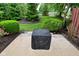 Landscaped backyard featuring lush green bushes, mulch beds, and concrete patio at 9154 Sea Oats Dr, Indianapolis, IN 46250