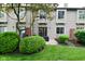 Exterior view of townhome with sliding glass door, small patio, and manicured bushes in backyard at 9154 Sea Oats Dr, Indianapolis, IN 46250