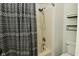 Bathroom featuring a tub with a shower and patterned curtain, complemented by bronze fixtures and neutral tile at 9154 Sea Oats Dr, Indianapolis, IN 46250
