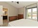 Light-filled bedroom featuring a large window, adjacent bath and two dressers, perfect for storage and comfort at 9154 Sea Oats Dr, Indianapolis, IN 46250