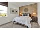 Cozy bedroom with a decorative wood accent wall, bright natural light, and plush carpeting at 9363 Abner St, McCordsville, IN 46055