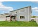Backyard view featuring a light blue house with a covered patio and luscious green grass at 951 Parker Ln, Westfield, IN 46074