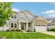 Inviting two-story home with a covered porch, stone details, manicured lawn, and lovely curb appeal at 951 Parker Ln, Westfield, IN 46074