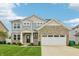 Charming two-story home with a stone facade, a two-car garage, and lush green landscaping at 951 Parker Ln, Westfield, IN 46074