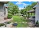 Expansive backyard featuring manicured lawn, mature trees, fountain, and charming white picket fence at 10036 E Troy Ave, Indianapolis, IN 46239
