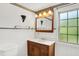 A bathroom featuring white tile, a wooden vanity, and decorative fixtures at 10036 E Troy Ave, Indianapolis, IN 46239