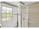 Bathroom with white tile, a walk-in shower, and a view to the backyard at 10036 E Troy Ave, Indianapolis, IN 46239