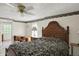 A warm bedroom boasting a decorative ceiling fan, a wooden bed frame, and ample natural light at 10036 E Troy Ave, Indianapolis, IN 46239