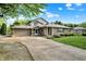 Attractive home boasts a paved driveway, attached garage, and well-maintained landscaping at 10036 E Troy Ave, Indianapolis, IN 46239