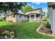 Well-maintained home exterior with lush green lawn and landscaped flowerbeds at 10036 E Troy Ave, Indianapolis, IN 46239
