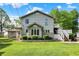 Two-story home on large lot with stone foundation and elevated deck with stairs at 10036 E Troy Ave, Indianapolis, IN 46239