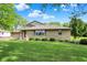 Landscaped front yard featuring mature trees and manicured bushes at 10036 E Troy Ave, Indianapolis, IN 46239