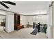 Bright living room with plush carpeting, large bookcase, and staircase to upstairs at 10036 E Troy Ave, Indianapolis, IN 46239