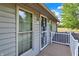 View of porch with secure entry door, adjacent windows and wood flooring at 10036 E Troy Ave, Indianapolis, IN 46239