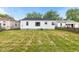 View of the house from the backyard, featuring a grassy lawn and mature trees at 1108 N Ritter Ave, Indianapolis, IN 46219