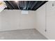An unfinished basement offers carpeting and natural light from a small window at 1108 N Ritter Ave, Indianapolis, IN 46219