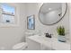 Updated bathroom features a modern vanity, round mirror, framed artwork, and a toilet at 1108 N Ritter Ave, Indianapolis, IN 46219