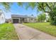 Charming single-story home with stone facade, attached garage and a concrete driveway at 1108 N Ritter Ave, Indianapolis, IN 46219