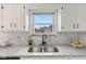Updated kitchen features granite counters, stainless steel sink, tiled backsplash and window with a view at 1108 N Ritter Ave, Indianapolis, IN 46219