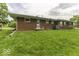 Back of ranch home featuring a brick exterior, rear access door, and well-maintained lawn at 1190 W Jefferson St, Franklin, IN 46131