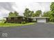 Rear view of ranch home with two car garage, paved driveway, and large grassy area at 1190 W Jefferson St, Franklin, IN 46131