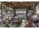 Cluttered garage interior view with a lawnmower and shelves stacked with items at 1190 W Jefferson St, Franklin, IN 46131