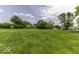 A large, lush green lawn with a few trees and a house in the background at 1190 W Jefferson St, Franklin, IN 46131