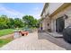 Paver patio features a seating area, lush lawn, beautiful landscaping, and sliding glass doors to the home's interior at 12082 Old Stone Dr, Indianapolis, IN 46236