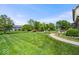 Expansive backyard features mature trees, lush lawn, a stone paver walkway, and a backyard playground at 12082 Old Stone Dr, Indianapolis, IN 46236