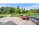 View of paver patio with a bench and seating area overlooking the expansive and beautifully landscaped backyard and playground at 12082 Old Stone Dr, Indianapolis, IN 46236