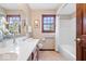 Bright bathroom featuring a double sink vanity, tiled floor, and a window for natural light at 12082 Old Stone Dr, Indianapolis, IN 46236