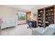 Well-lit bedroom featuring a crib, bookshelves, a desk with chair, and an accent chair at 12082 Old Stone Dr, Indianapolis, IN 46236