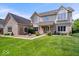 Elegant two-story home featuring brick and siding exterior, complemented by a lush green lawn and mature landscaping at 12082 Old Stone Dr, Indianapolis, IN 46236