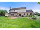 The home's backyard features beautiful landscaping, a manicured lawn, a paver patio, and brick accents at 12082 Old Stone Dr, Indianapolis, IN 46236